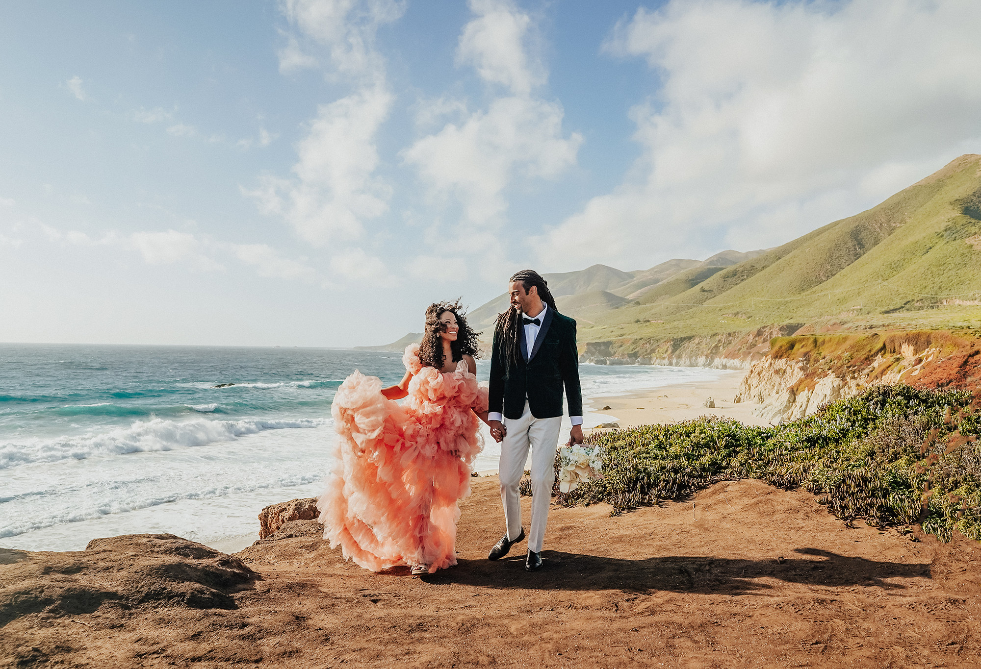 black couple eloping in Big sur wearing a pink tulle dress and a velvet green tuxedo